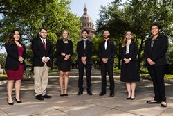 students standing together with Austin Capital building in the background