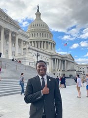 Aggie intern in a suit outside the capitol in Washington D.C.