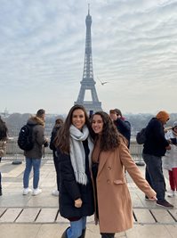 two female students in foreground posing with Iffil tower in the background